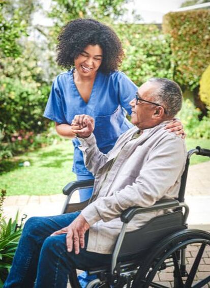 man in wheelchair with nurse outside